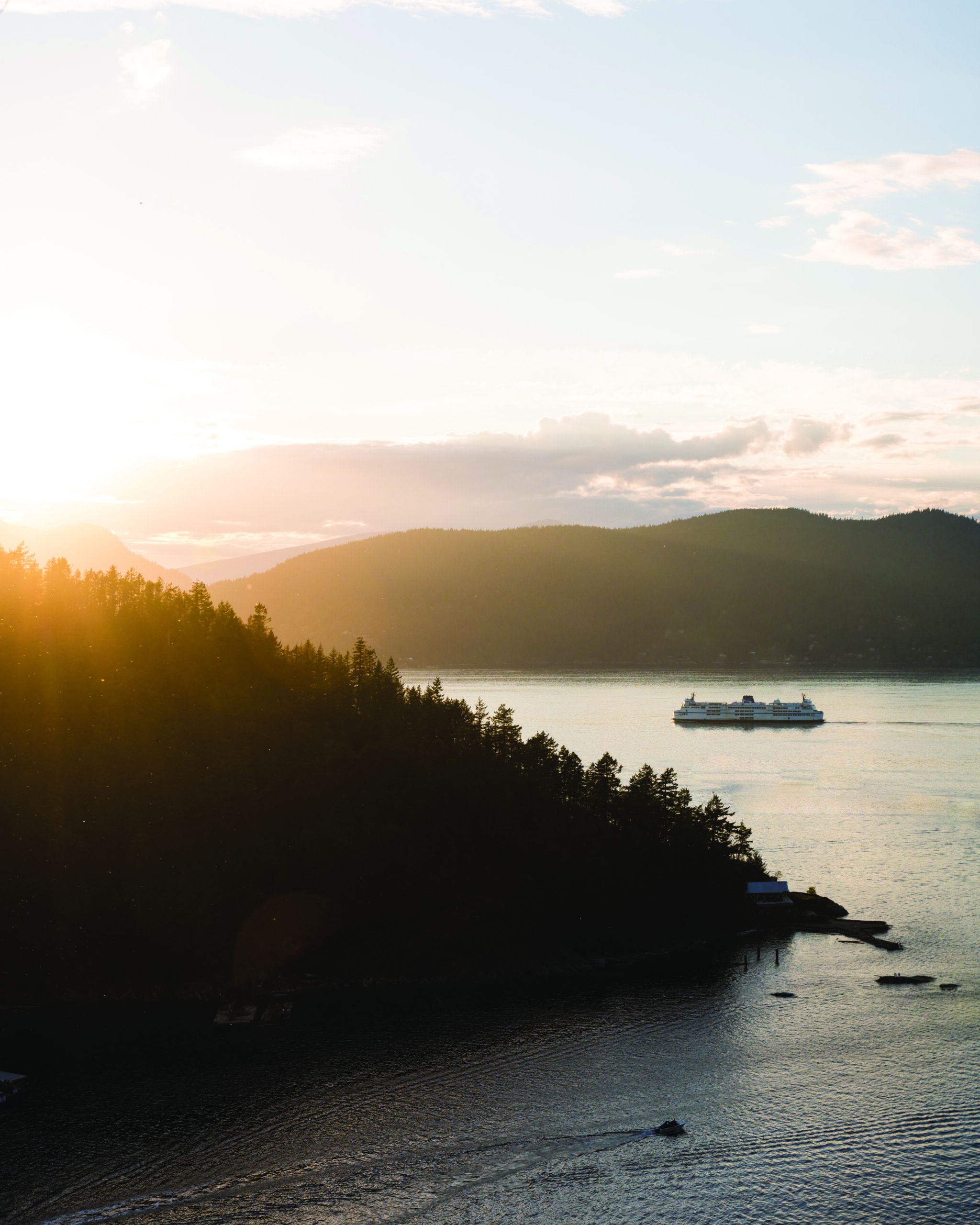 A Ferry Sailing At Sunset Through A Mountainous Area Of The British Columbia Coast